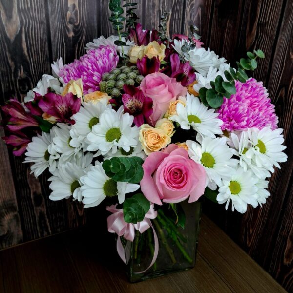 A Garden in Soft Focus bouquet with roses chrysanthemums lilac-pink carnations lisianthus and greenery in a glass vase