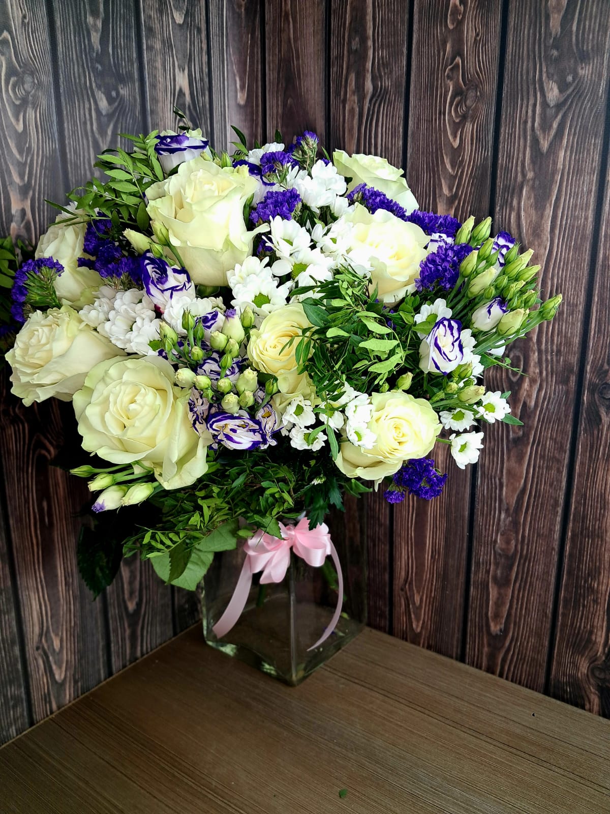 White roses and purple lisianthus bouquet with fresh greenery