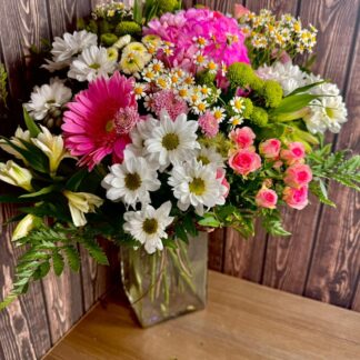 A Summer Keepsake summer flower bouquet with hydrangea spray roses gerbera and chamomile chrysanthemums in a glass vase