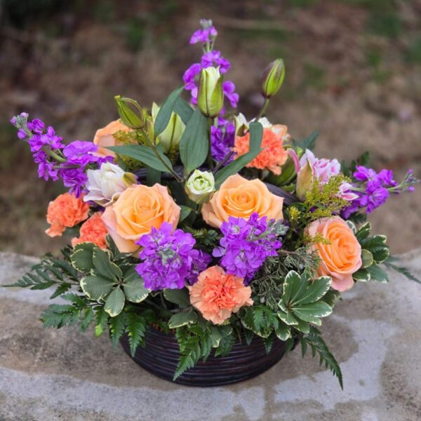 Harmony of Nature orange rose bouquet with lilies, fragrant matthiola and chrysanthemums in a wicker basket