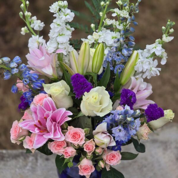 Lily and rose bouquet with matthiola, spray roses and statice in a graceful floral arrangement