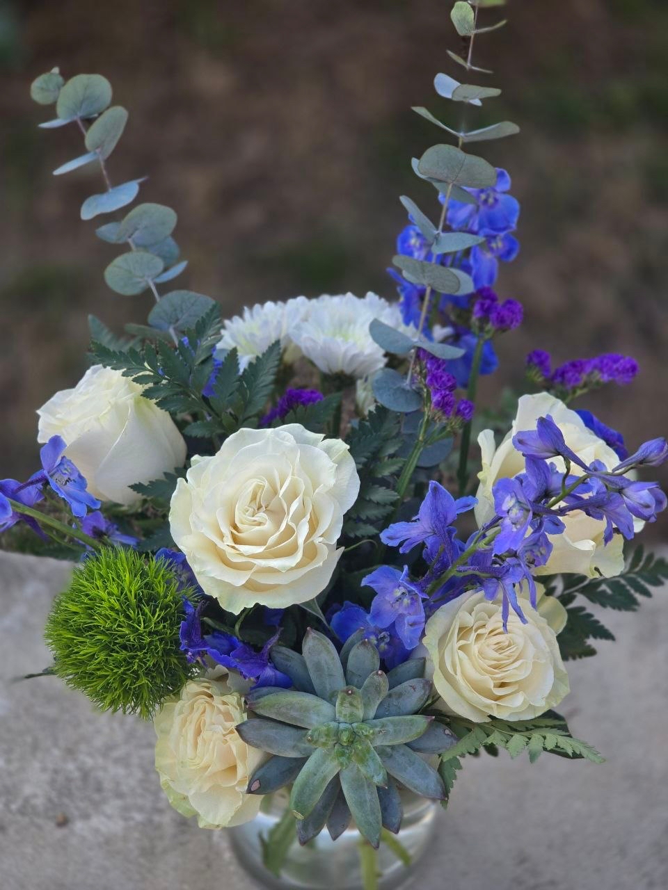 A bouquet in a glass vase with a white rose and blue delphinium - Image 2