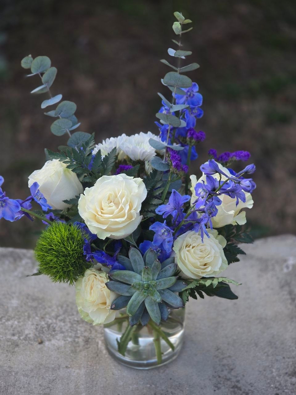 A bouquet in a glass vase with a white rose and blue delphinium - Image 3