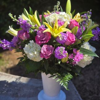 A luxurious bouquet in a vase with lilies, white hydrangea, and lilac matthiola