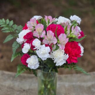 A bouquet with spray roses and alstroemeria in a glass vase