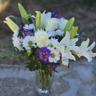 А bouquet of lilies and roses in a glass vase