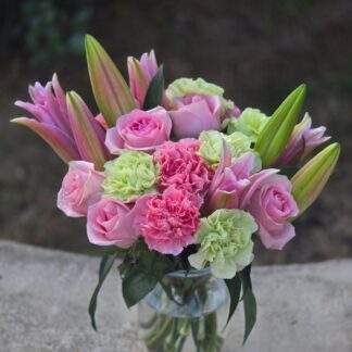 Bouquet in a glass vase with pink lily, rose, carnation