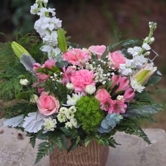 A bouquet in a glass vase with a pink rose, white matthiola, pink alstroemeria, and lily
