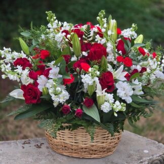 Bouquet in a wicker basket with white lily, red rose, spray rose