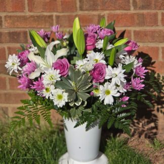 Business bouquet in a plastic vase with a white lily, a pink rose, and white and pink spray chrysanthemum