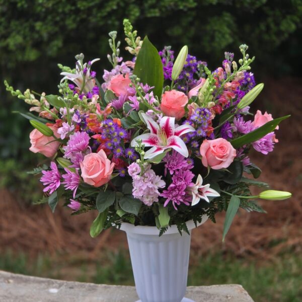 White and pink flower arrangement with white lilies, pink roses, matthiola, chrysanthemums and greenery in a white vase