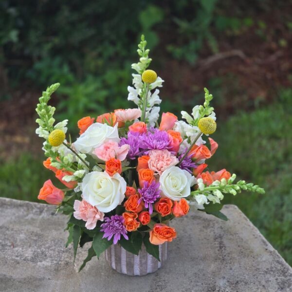 Autumn Sunset orange rose arrangement with white matthiola, pink carnations and yellow craspedia in a vase
