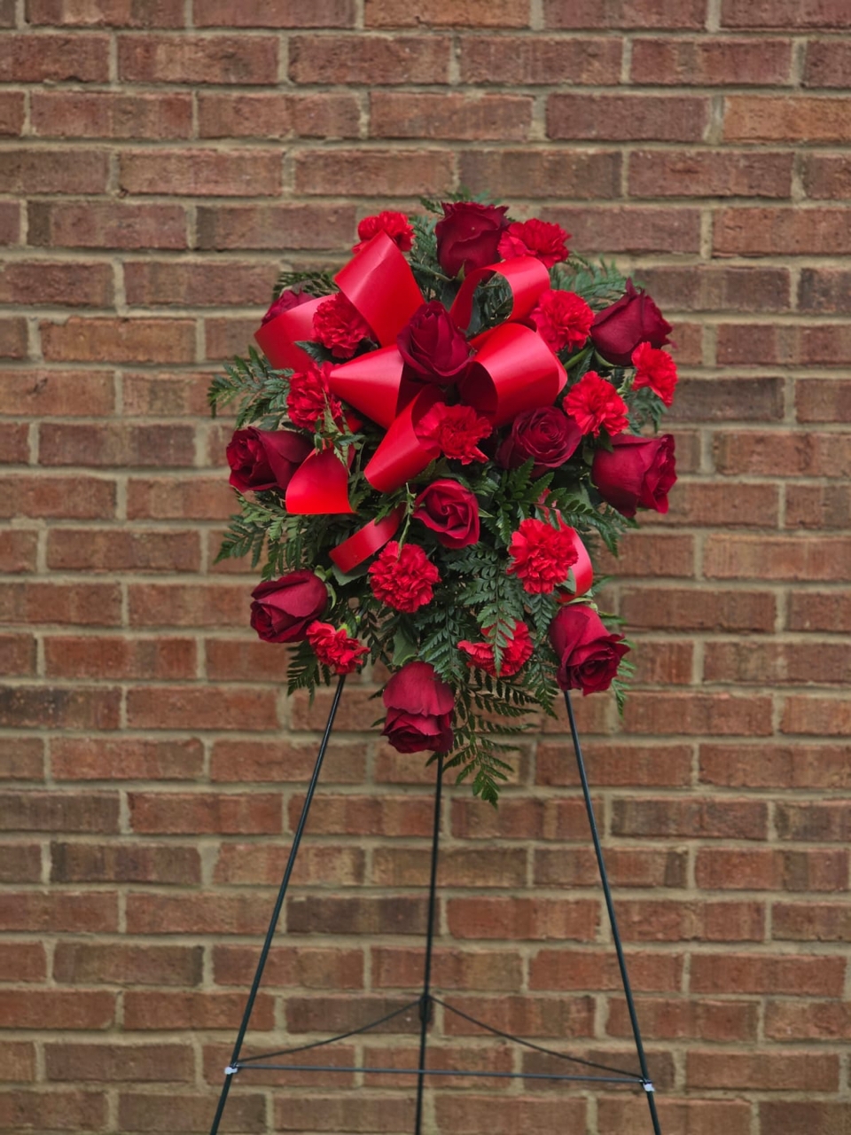 Eternal Love Tribute red funeral flower arrangement with red roses, carnations and fresh fern