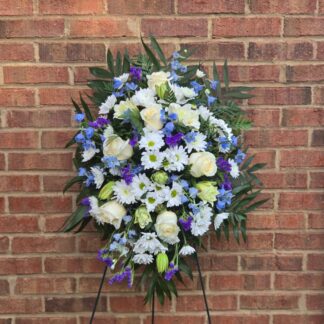 White and blue funeral standing spray with chrysanthemums, lilies, roses, delphinium and fern