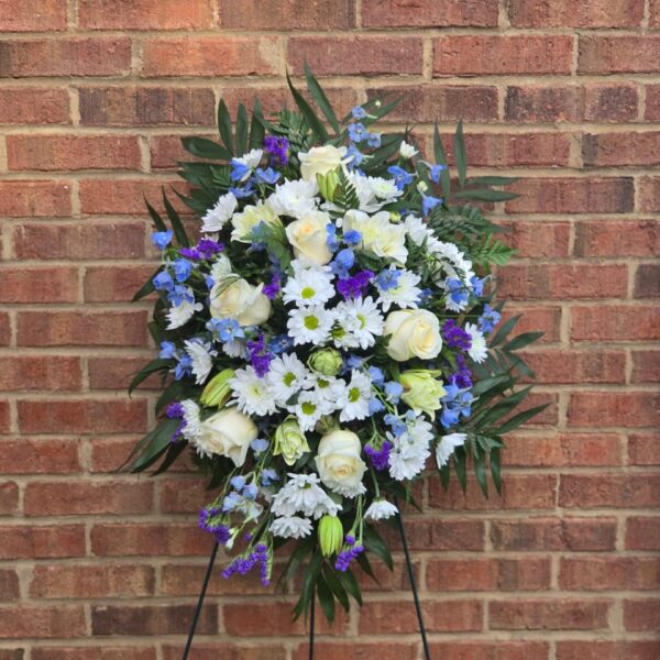 White and blue funeral standing spray with chrysanthemums, lilies, roses, delphinium and fern